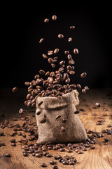 Fototapeta premium cascata di chicchi di caffè in sacco di iuta
