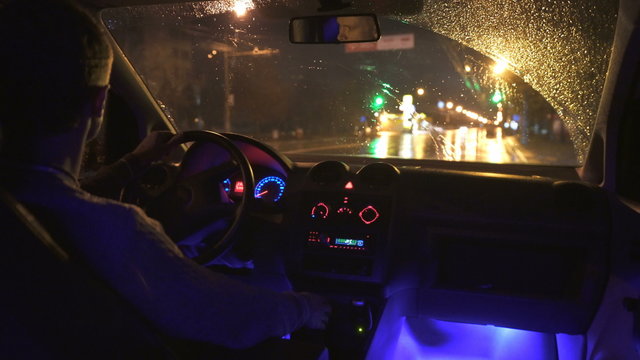 2 in 1 video! The man drive a car in the rainy city. Inside view. Evening-night time, real time capture. Wide angle