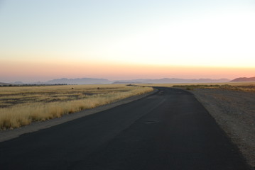 Morning view of road and savanna in Namibia dark blue sky