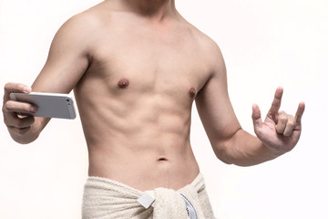 Fototapeta premium Man taking a selfie with his phone and show his hand in I love you