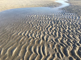 Sand ripples and water on the beach, Jacksonville Beach, Florida, USA. 