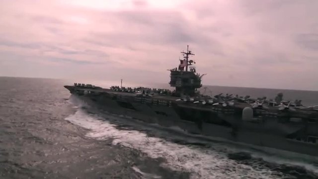 Good aerial over an aircraft carrier as sea.