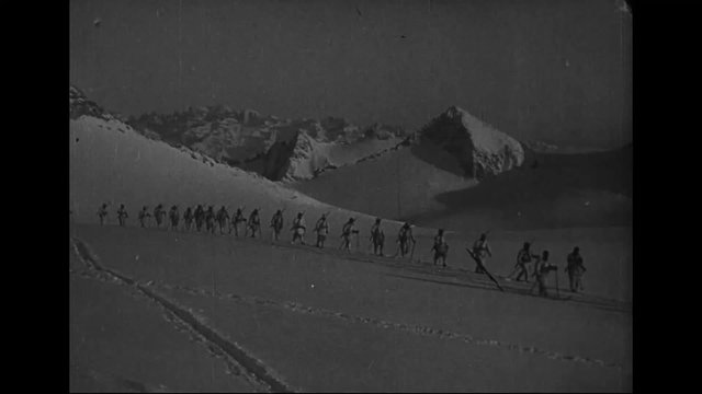 The Italian army in World War One uses skis to cross the Alps.