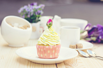 Light yellow Cupcake with rose on the table