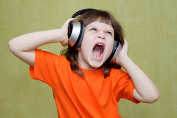 Girl listening to music on headphones and sings