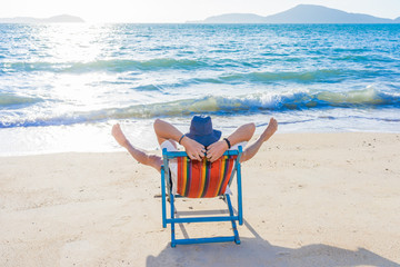 Fototapeta na wymiar Man relaxing on beach, ocean view