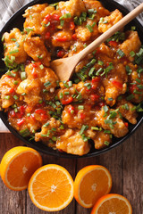 Delicious orange chicken fillets close-up on a plate. vertical top view 
