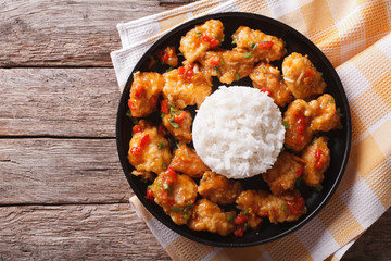 chicken in orange sauce with rice on a plate. horizontal top view
