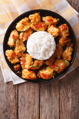 chicken in orange sauce with rice on a plate. vertical top view
