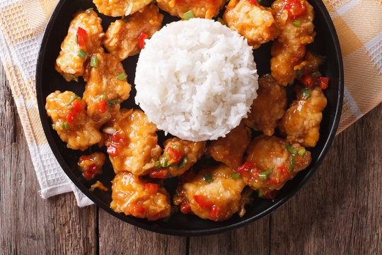 Orange Chicken With Rice Garnish Close Up On A Plate. Horizontal Top View 
