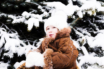 small girl in a sled near fir-tree