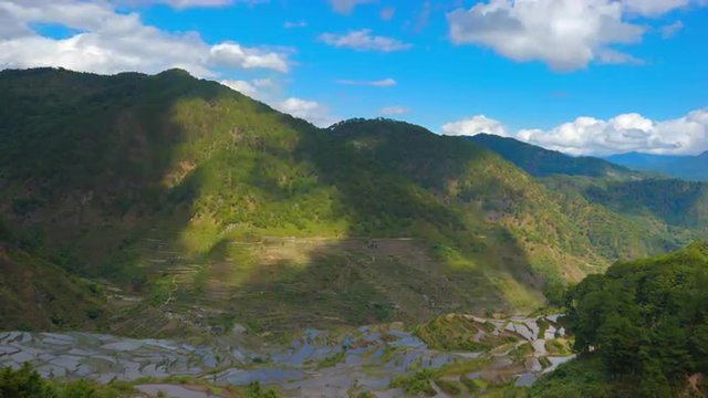 HDR nature timelapse of clouds over green rice terraces on mountain hill in Asia