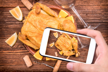 Fototapeta premium Hands taking photo cooked chicken with smartphone.
