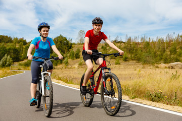 Obraz premium Healthy lifestyle - teenage girl and boy cycling 