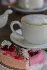 Delicious cakes, a cup of cappuccino and milk foam