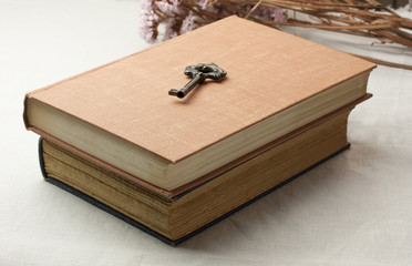 Two old books with vintage key on top