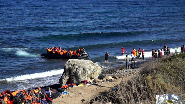 Boat with refugees swam to the shore of the island of Lesvos, Greece. Dangerous and illegal way through the sea from Turkey to the European Union. People on the shore of their encounter to help.