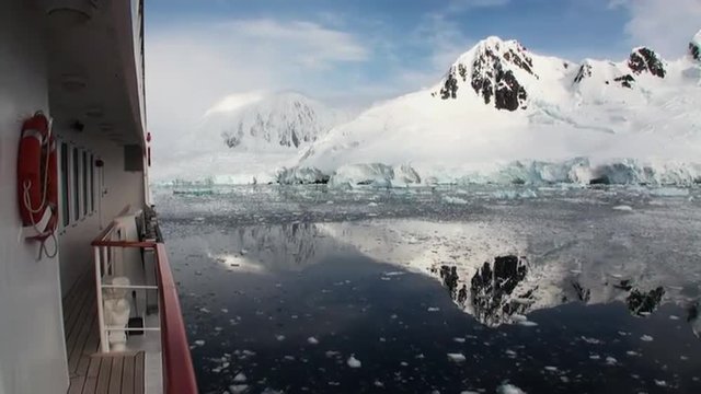Moving Ice Floes and Ice Sheets in the calm Antarctic Sea, Reflection of Antarctica Mountain in water surface. Amazing beautiful views of Nature and landscape of snow, ice and white of Antarctic.