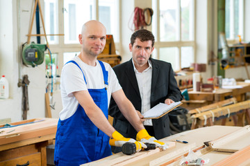 boss and worker in carpenter's workshop