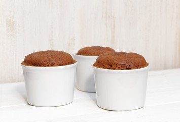 Three homemade chocolate cake on white ceramic form
