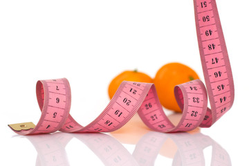 fruits and measuring tape on a white background to symbolize diet