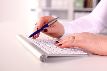Female office worker typing on the keyboard