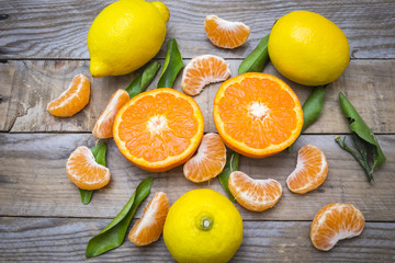 several mature citrus on a wooden table - lemon and tangerine

