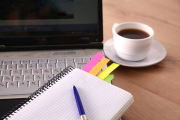 Office table with blank notepad and laptop 