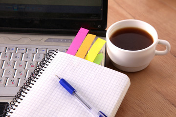 Office table with blank notepad and laptop 