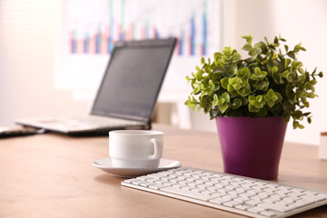 Office table with blank notepad and laptop 