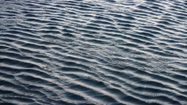 Beautiful surface. Ripples in water, different depths harmonic fluting
