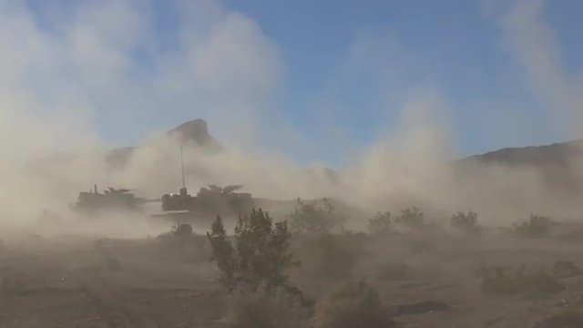 U.S. army tanks fire in the desert.