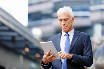 Senior businessman holding touchpad 