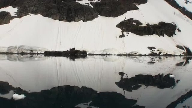 Moving Ice Floes and Ice Sheets in the calm Antarctic Sea, Reflection of Antarctica Mountain in water surface. Amazing beautiful views of Nature and landscape of snow, ice and white of Antarctic.