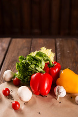Fresh vegetables, bulgarian pepper, lettuce, garlic, mushrooms, cherry tomatoes and spices on wooden background