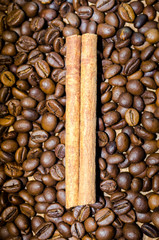 Brown coffee beans and cinnamon sticks background