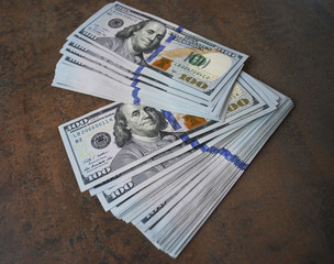 Cash dollar banknotes spread out on the table. Only hundreds.