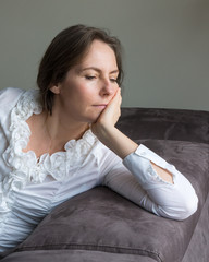 femme pensive sur son canapé