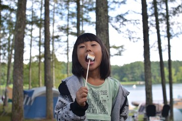 Fototapeta premium バーベキューでマシュマロを食べる女の子