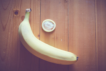 banana con preservativo su fondo legno © CreativePhotography