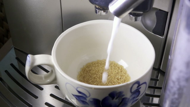 the made foam milk is poured in a cup, slow motion