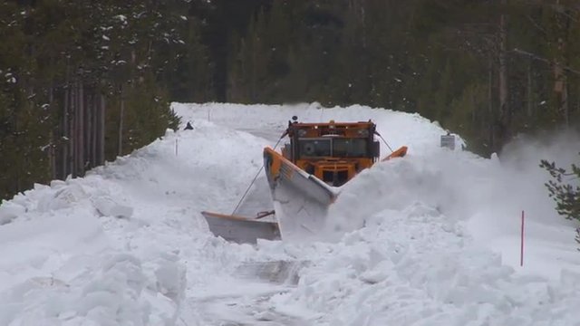 Snowplows clear roads in Yellowstone National park.
