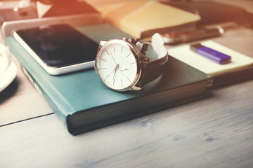 watch and phone on book,coffee on table