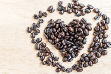 Coffee beans in heart shape  on wooden background