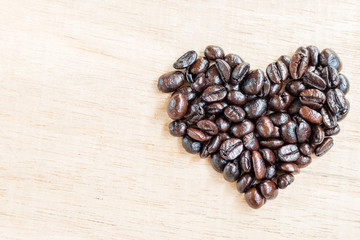 Coffee beans in heart shape  on wooden background