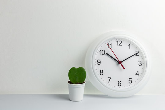 Clock and cactus with hreat shape on white background