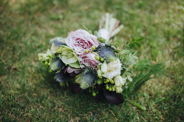 bouquet of purple flowers and greenery is on the green grass