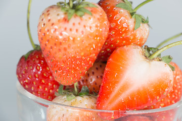 Ripe strawberries in saucer on wooden table on blurred backgroun