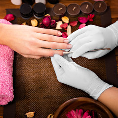 Obraz na płótnie Canvas Closeup finger nail care by manicure specialist in beauty salon. 