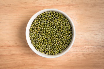 bowl of green bean seed on a wood background